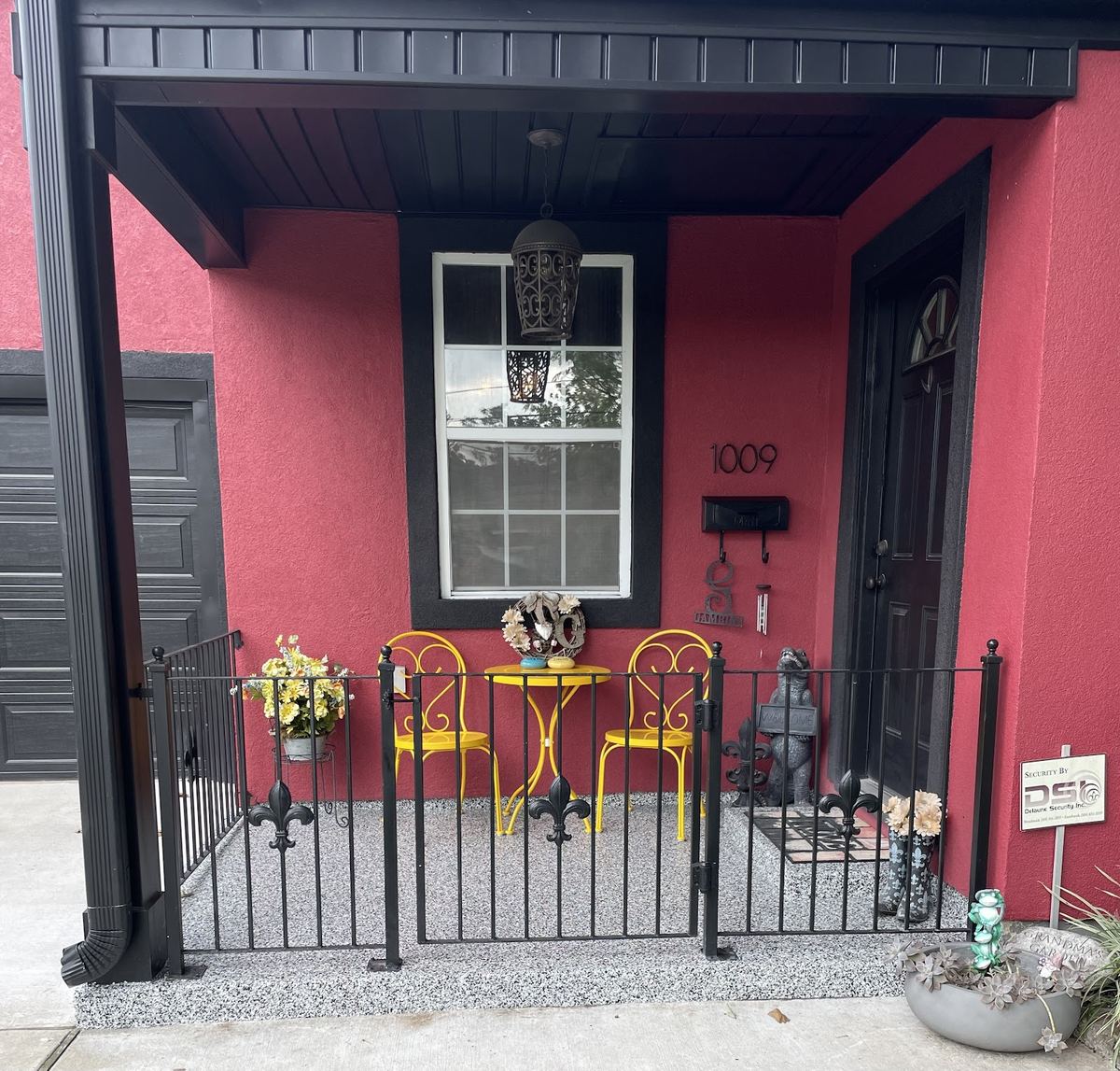 Coated front porch with fleur-de-lis iron railings — a real Omega project